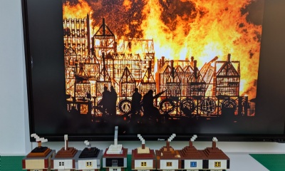 Lego models of houses with the great fire of London image in the background